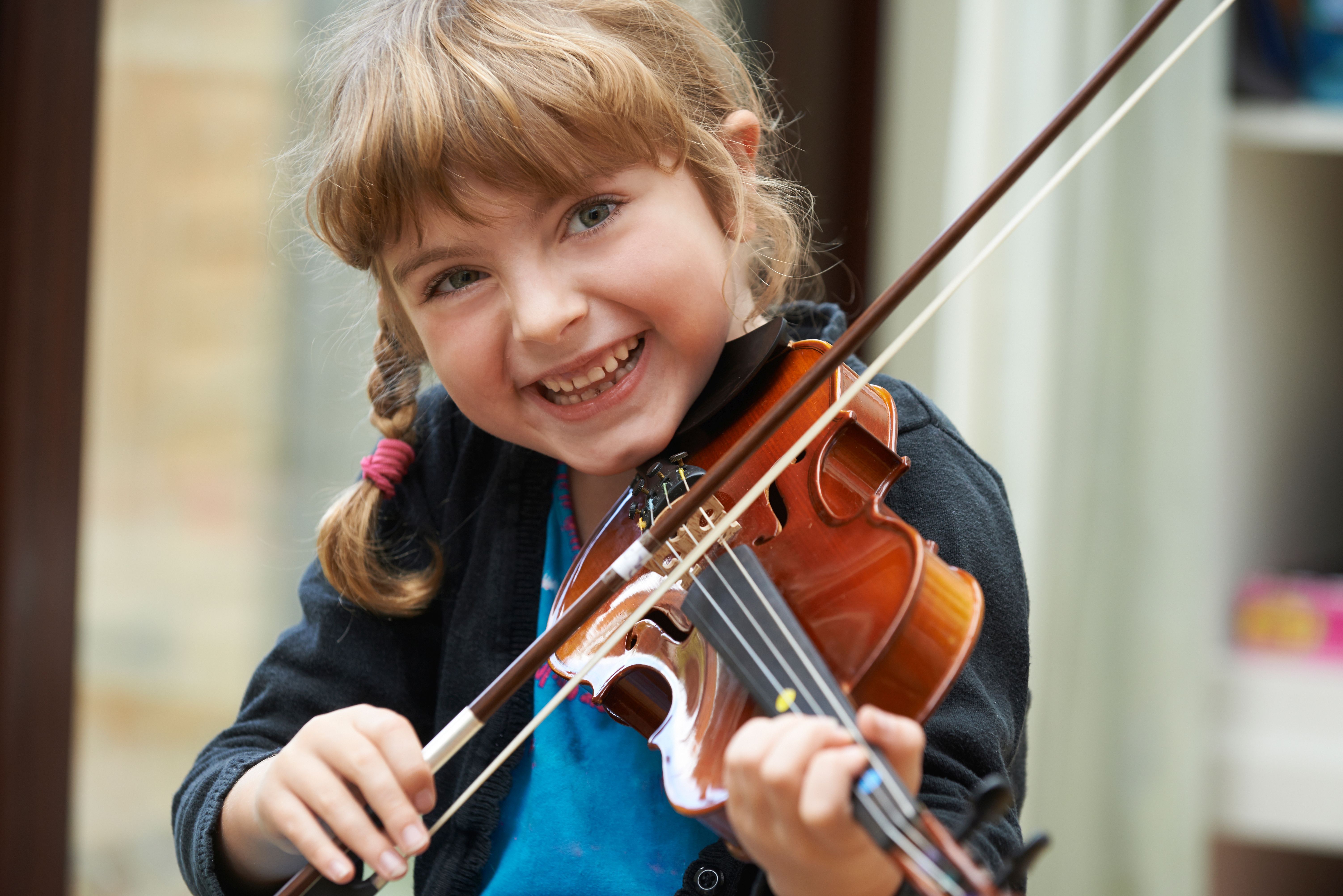Portrait Of Young Girl Learning To Play Violin